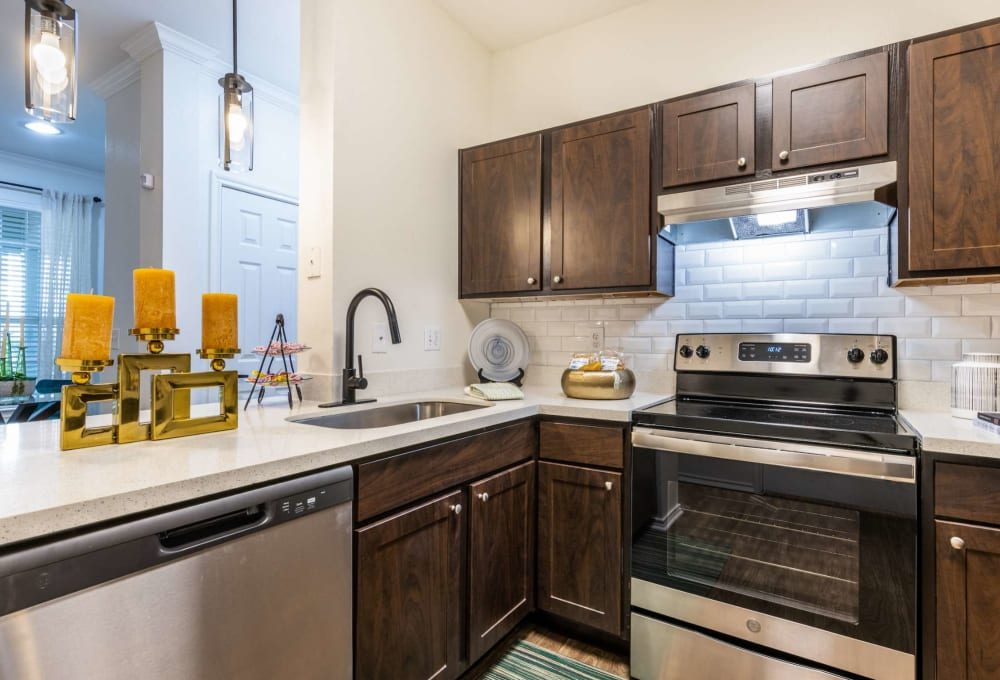 a kitchen with stainless steel appliances and wood cabinets at The  Pines on Spring Rain